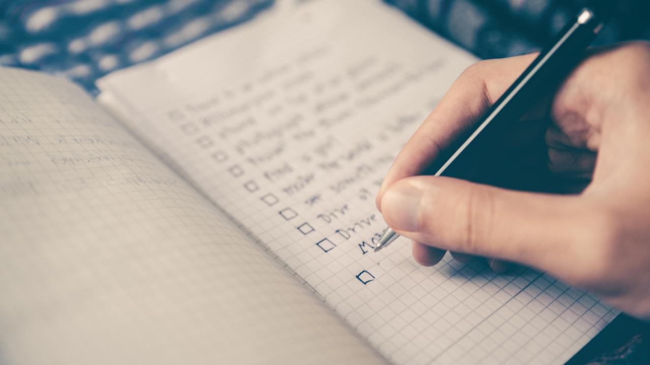 Person writing an SEO audit checklist